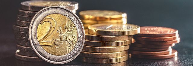 Gestapelte Euro-Münzen, im Vordergrund eine 2-Euro-Münze