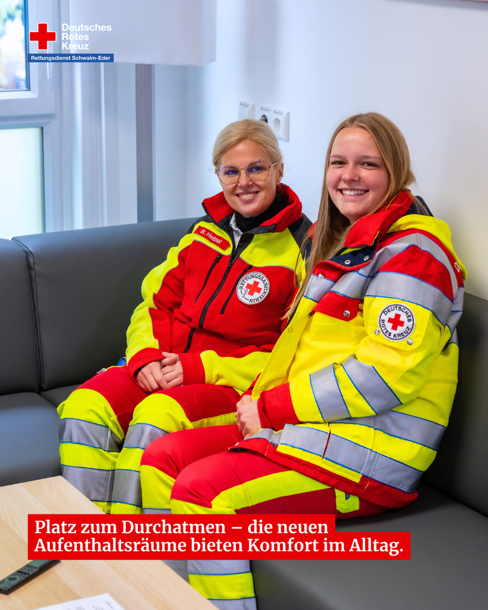 Zwei Mitarbeiterinnen des Rettungsdienstes sitzen in den neuen Aufenthaltsräumen und lächeln in die Kamera.