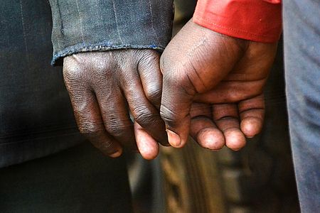 Zwei Menschen halten sich an den Händen – eine Geste der Nähe, Unterstützung und Verbundenheit.