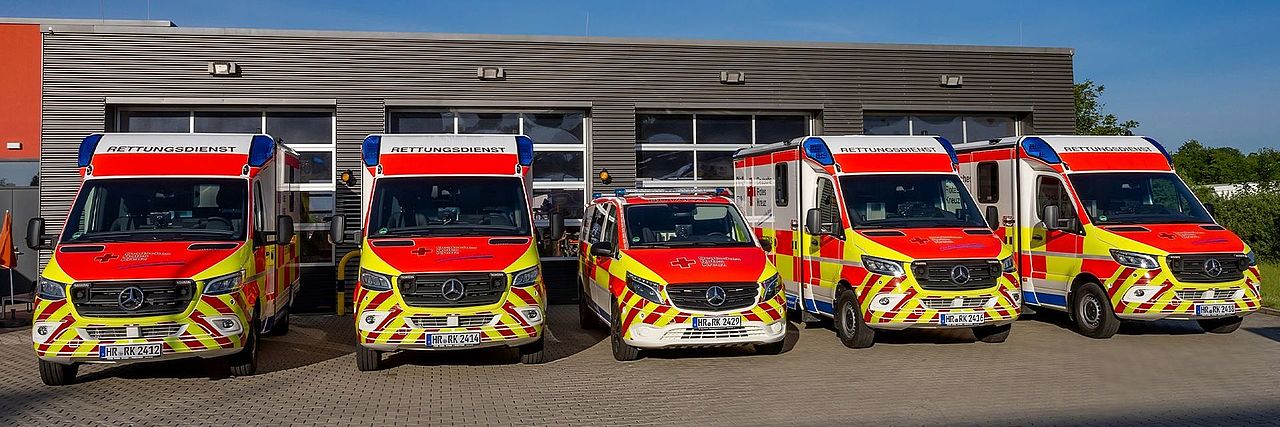 Fünf Rettungswagen des DRK stehen nebeneinander vor der Rettungswache