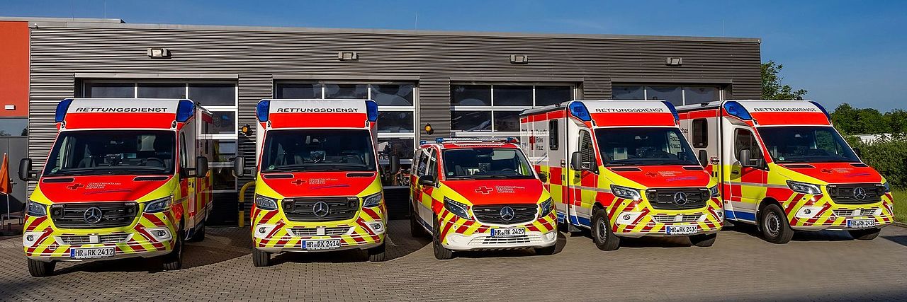 Fünf Rettungswagen des DRK stehen nebeneinander vor der Rettungswache