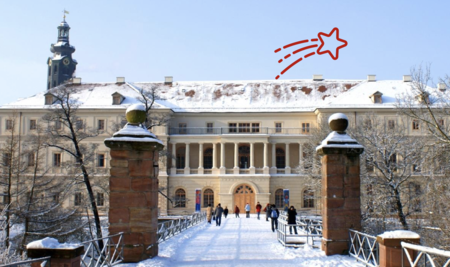 Alt-Text:  Das winterlich verschneite Stadtschloss Weimar mit seinem Schlossturm, aufgenommen von der zuführenden Brücke mit Sandsteinpfeilern.