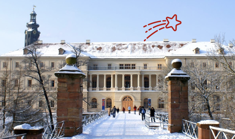 2026_08_19_Weimar_im_Weihnachtsglanz Alt-Text: Das winterlich verschneite Stadtschloss Weimar mit seinem Schlossturm, aufgenommen von der zuführenden Brücke mit Sandsteinpfeilern.