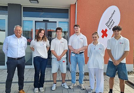 Gruppenfoto der sechs Mitglieder des Werbeteams in weißem DRK-Poloshirt und Kreisgeschäftsführer Manfred Lau vor dem Eingang des DRK-Kreisverbands..