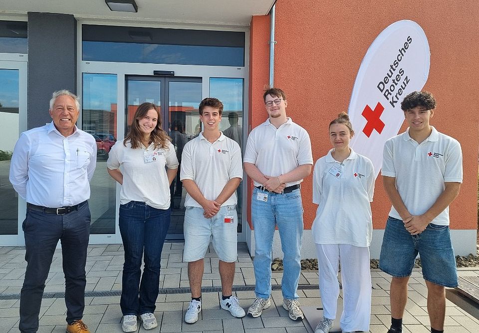 Gruppenfoto der sechs Mitglieder des Werbeteams in weißem DRK-Poloshirt und Kreisgeschäftsführer Manfred Lau vor dem Eingang des DRK-Kreisverbands..