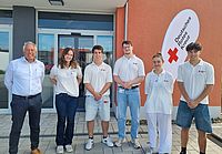 Gruppenfoto der sechs Mitglieder des Werbeteams in weißem DRK-Poloshirt und Kreisgeschäftsführer Manfred Lau vor dem Eingang des DRK-Kreisverbands..