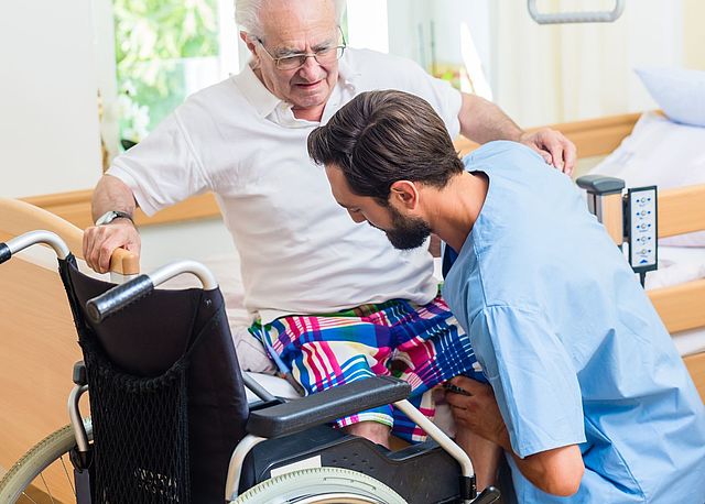 Pflegekraft kümmert sich um einen Senior im Rollstuhl