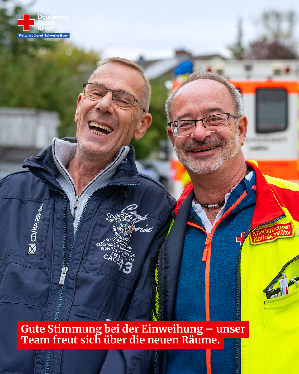 Zwei Rettungsdienstmitarbeiter lachen und freuen sich über die neuen Räume bei der Einweihung.